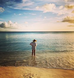 Full length rear view of woman standing on beach