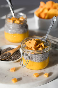 Mango chia pudding snacks in bright sunlight, ready for eating.