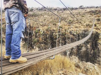 Low section of man on footbridge