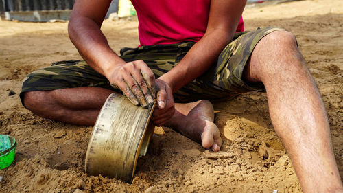 Low section of man working on sand