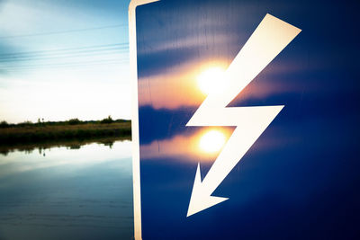 Close-up of illuminated sign against sky