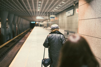 Rear view of people walking on railway station