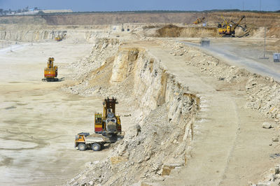 Excavator loading dumper truck on mining site