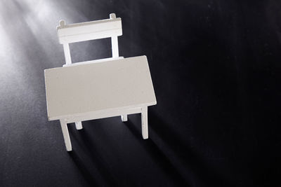 High angle view of empty table and chair on black background
