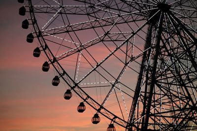 Low angle view of illuminated ferris wheel at kasai rinkai park during sunset