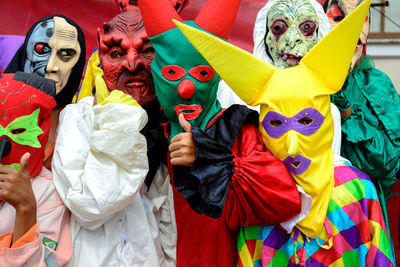 Group of people dressed in horror costumes against red background 