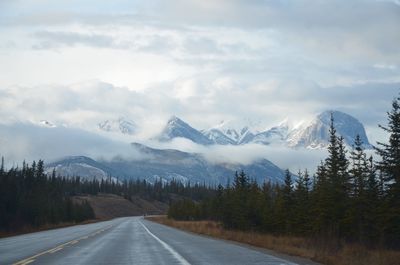 Road by mountains against sky