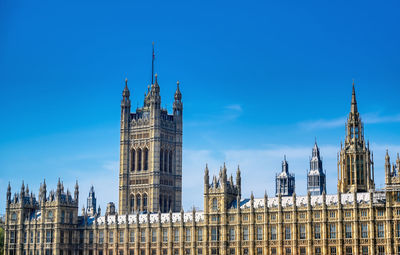 Buildings in city against blue sky