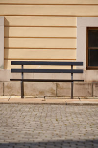 Empty bench against wall in building