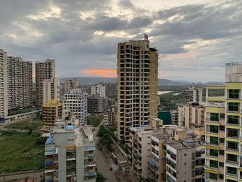 Buildings in city against sky during sunset