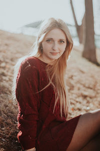 Portrait of beautiful young woman sitting on field