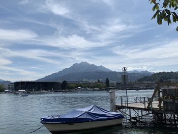 Boats moored in bay against sky