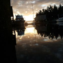 Silhouette sailboats in water at sunset
