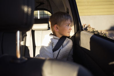 Boy sitting in electric car looking through window