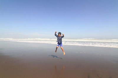 Full length of man on beach against clear sky