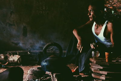 Thoughtful mature man looking away while sitting in hut