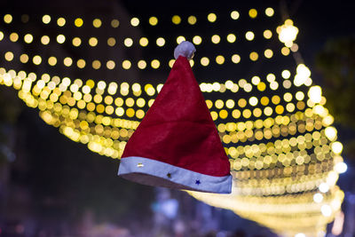 Low angle view of illuminated lighting equipment hanging at night