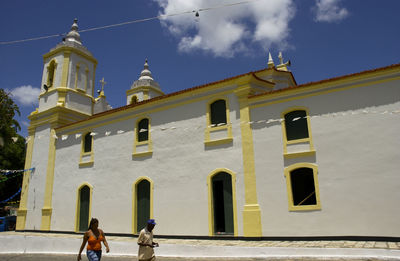 People outside historic building against sky