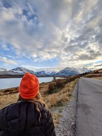 Rear view of woman looking at road against sky