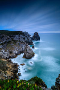 Rocks on sea shore against sky