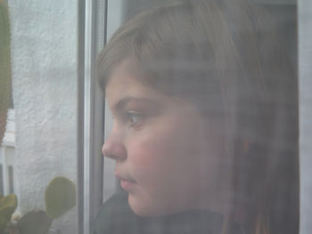 Portrait of woman looking through window