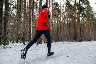 Male runner running winter marathon in forest
