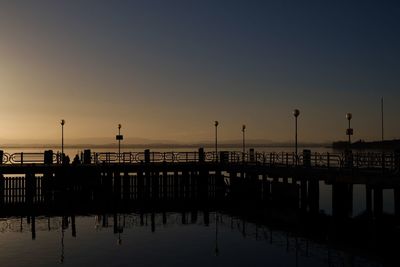 Silhouette pier on sea against sky during sunset