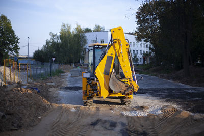 Yellow construction site by road against sky