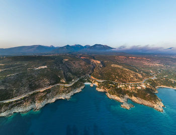 High angle view of sea and mountains against clear blue sky