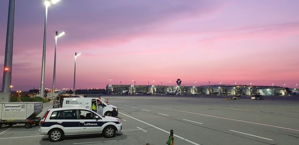 Cars on road against sky during sunset