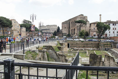 People walking on street against coliseum