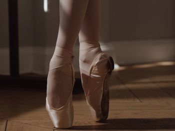 Low section of woman standing on hardwood floor