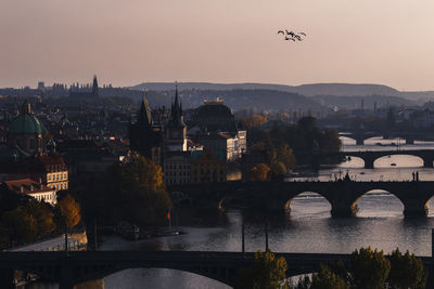 Bridge over river against buildings in city