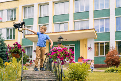 Boy standing by building