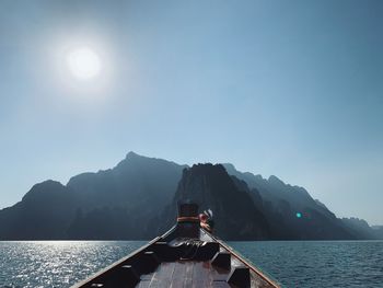 Scenic view of sea and mountains against clear sky