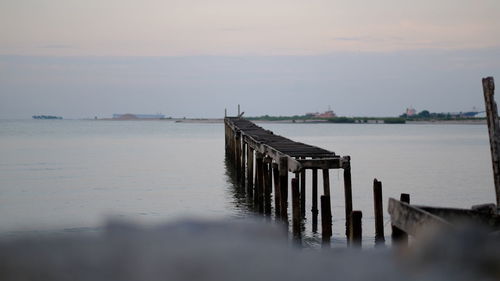 Pier over sea against sky during sunset