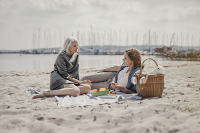 Mother and daughter having a picnic on the beach