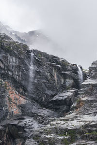Scenic view of waterfall and mountains against sky