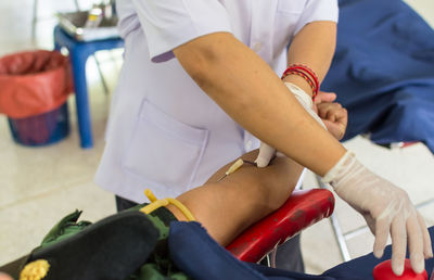 Close-up of nurse taking blood from patient in hospital