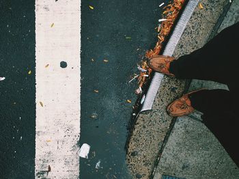 Low section of man standing on road