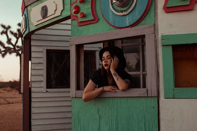 Young woman with eyes closed on window sill