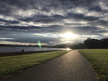 Road by land against sky during sunset