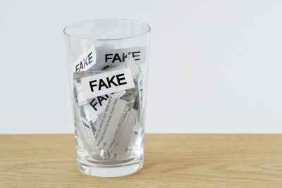 Close-up of glass on table against white background