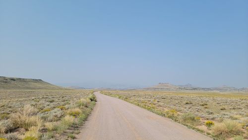 Road amidst desert against clear sky