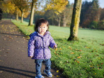 Portrait of cute baby girl standing on pathway at park