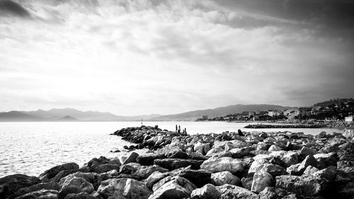 Rocks by sea against sky