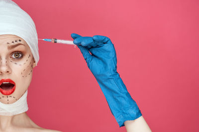 Midsection of woman holding hands against red background