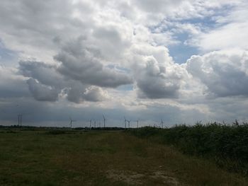 Scenic view of field against cloudy sky