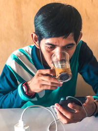 Portrait of young man holding drink