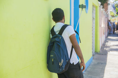 Rear view of man standing against wall